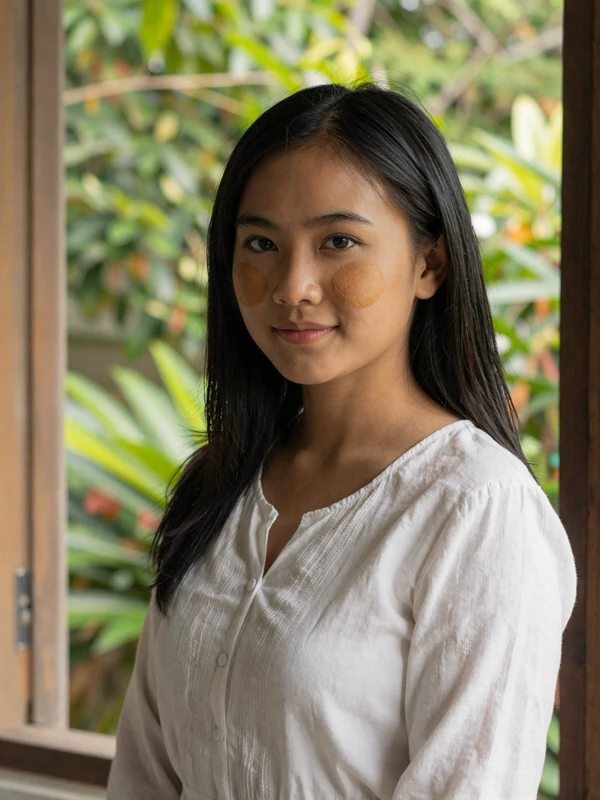 Burmese woman with traditional thanaka face paste wearing elegant blouse representing educated Myanmar singles seeking meaningful relationships