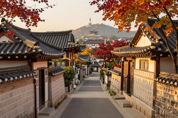 Traditional Korean hanok village in Bukchon Seoul with autumn foliage and Namsan Tower background