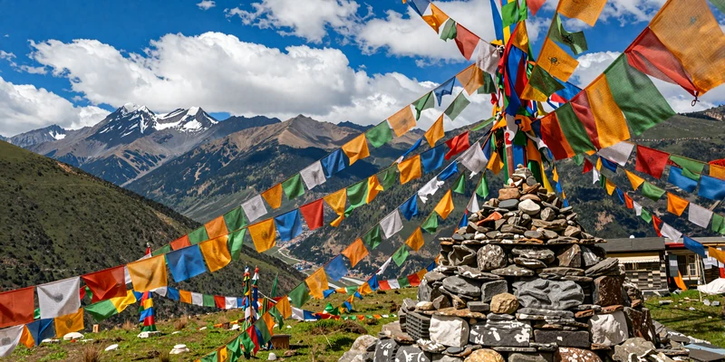 Colorful Buddhist prayer flags over Himalayan mountain pass representing Bhutanese spiritual traditions and culture