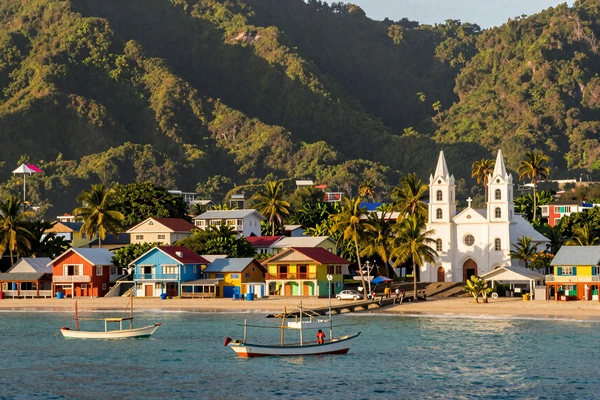 Beautiful Philippine coastal town with colorful houses and a Catholic church surrounded by tropical scenery