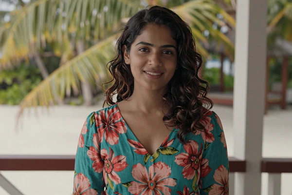 Maldivian woman in colorful modest dress on tropical island veranda representing Maldivian dating culture